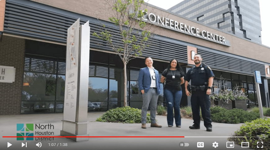 Screen capture of YouTube video from the 2023 Blue Star Training program with three HPD officers. From left are a Asian man in a blue suit, a beautiful woman in business dress with a badge and a uniformed Hispanic male police officer smiling outside a conference center.